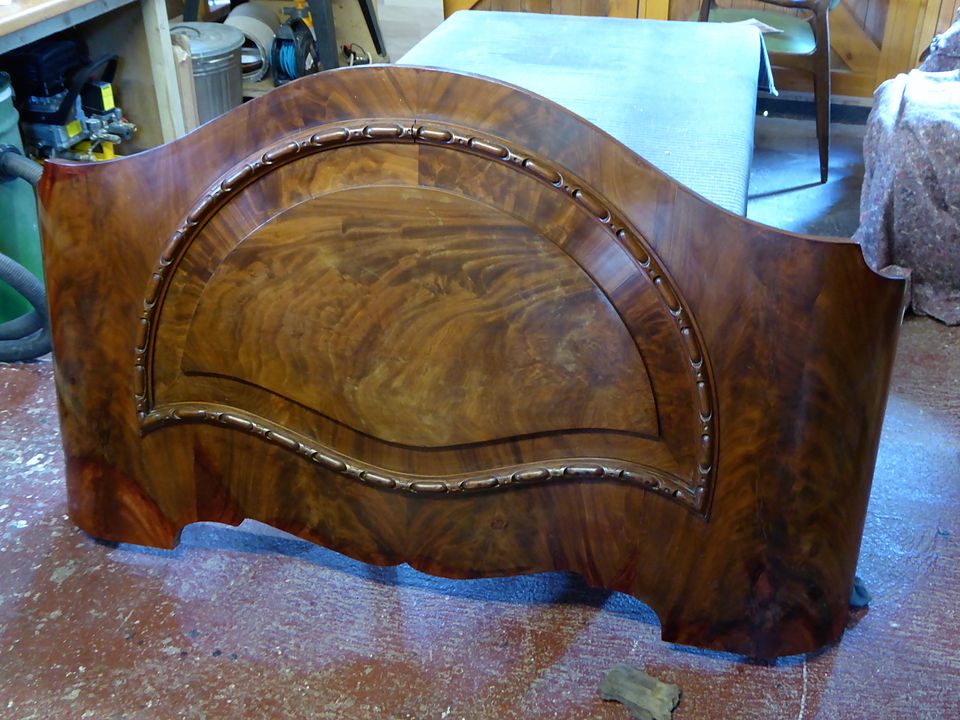 Restored headboard with flame-figured veneer and a carved rope moulding, veneer relaid and polished