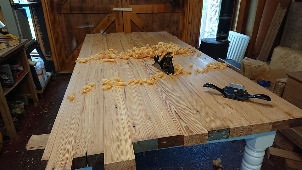 Hand planing a table top in the workshop